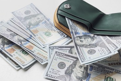 Photo of Dollar banknotes and wallet on white table, closeup. Money exchange