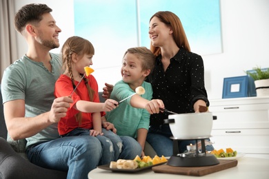 Happy family enjoying fondue dinner at home