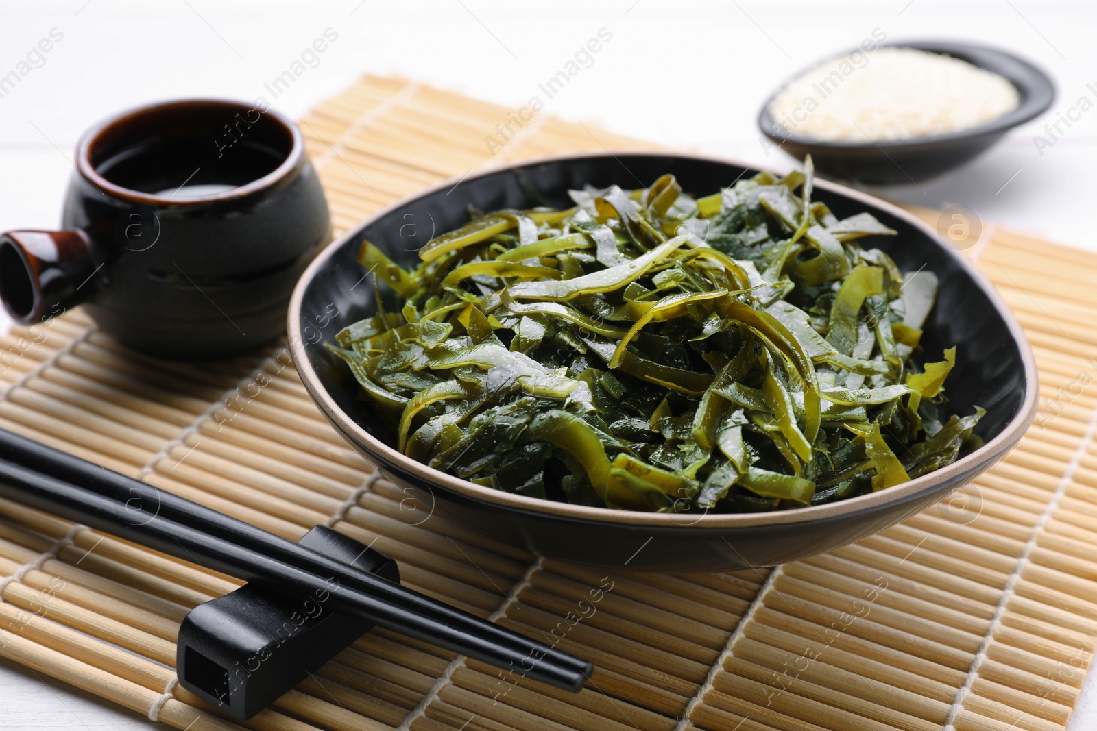 Photo of Fresh laminaria (kelp) seaweed served on white table