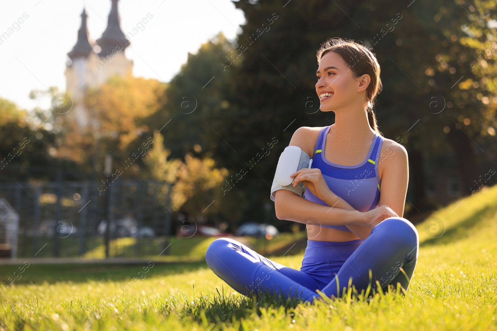 Photo of Happy woman checking blood pressure with modern monitor after training in park. Space for text