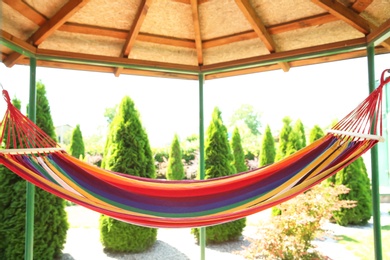 Photo of Gazebo with colorful hammock outdoors on sunny day