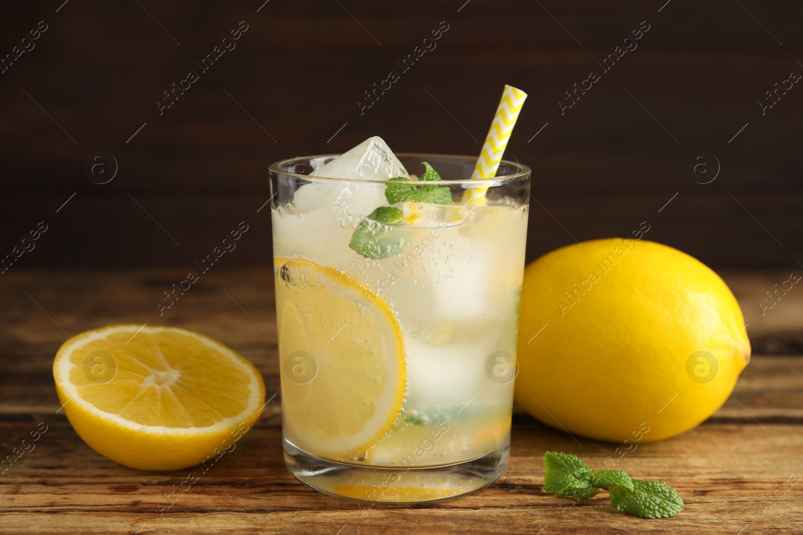 Photo of Cool freshly made lemonade and fruits on wooden table