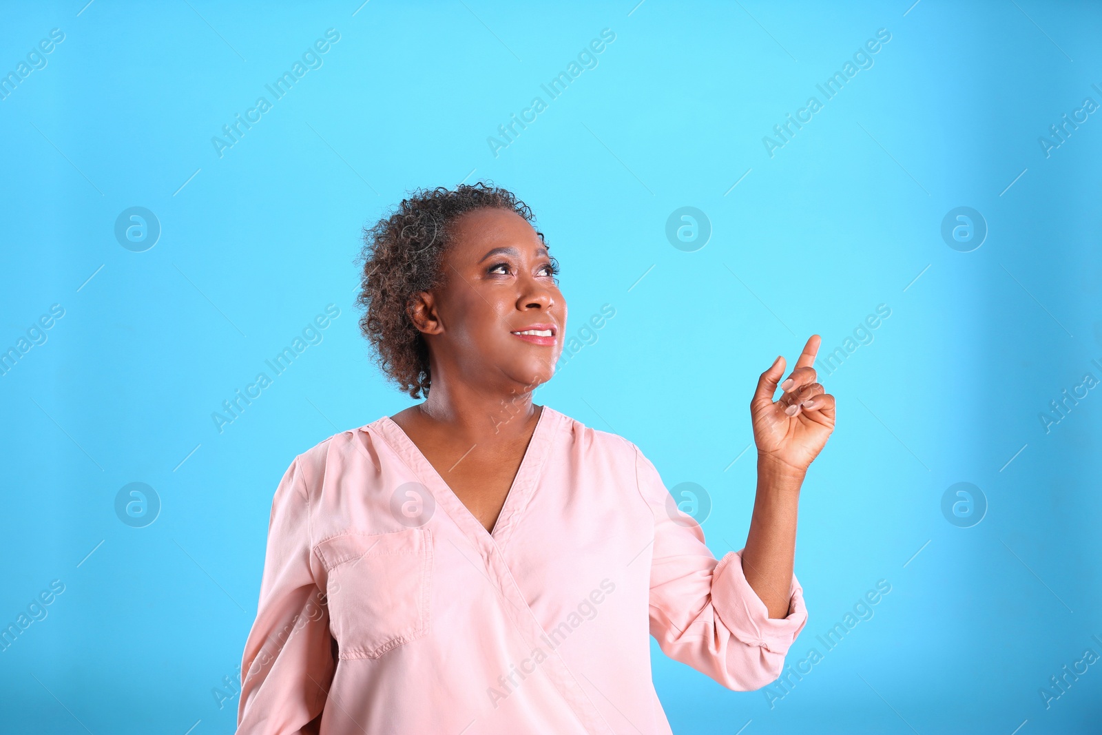 Photo of Portrait of happy African-American woman on light blue background