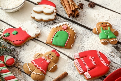 Photo of Delicious homemade Christmas cookies and flour on wooden table
