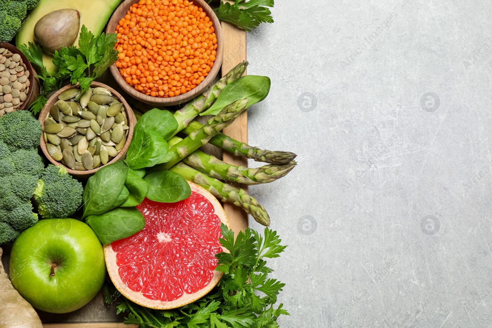 Photo of Fresh vegetables, fruits and seeds on grey table, flat lay. Space for text