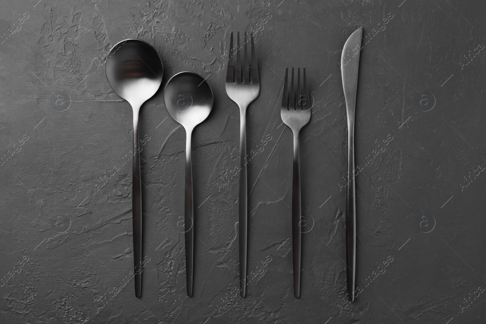 Photo of Beautiful cutlery set on black table, flat lay