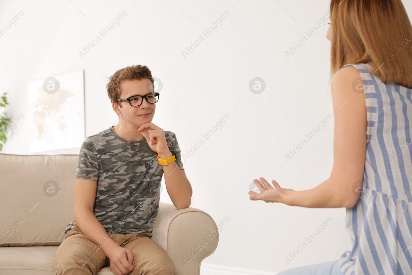 Photo of Mother talking with her teenager son at home