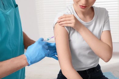 Photo of Doctor giving hepatitis vaccine to patient in clinic, closeup