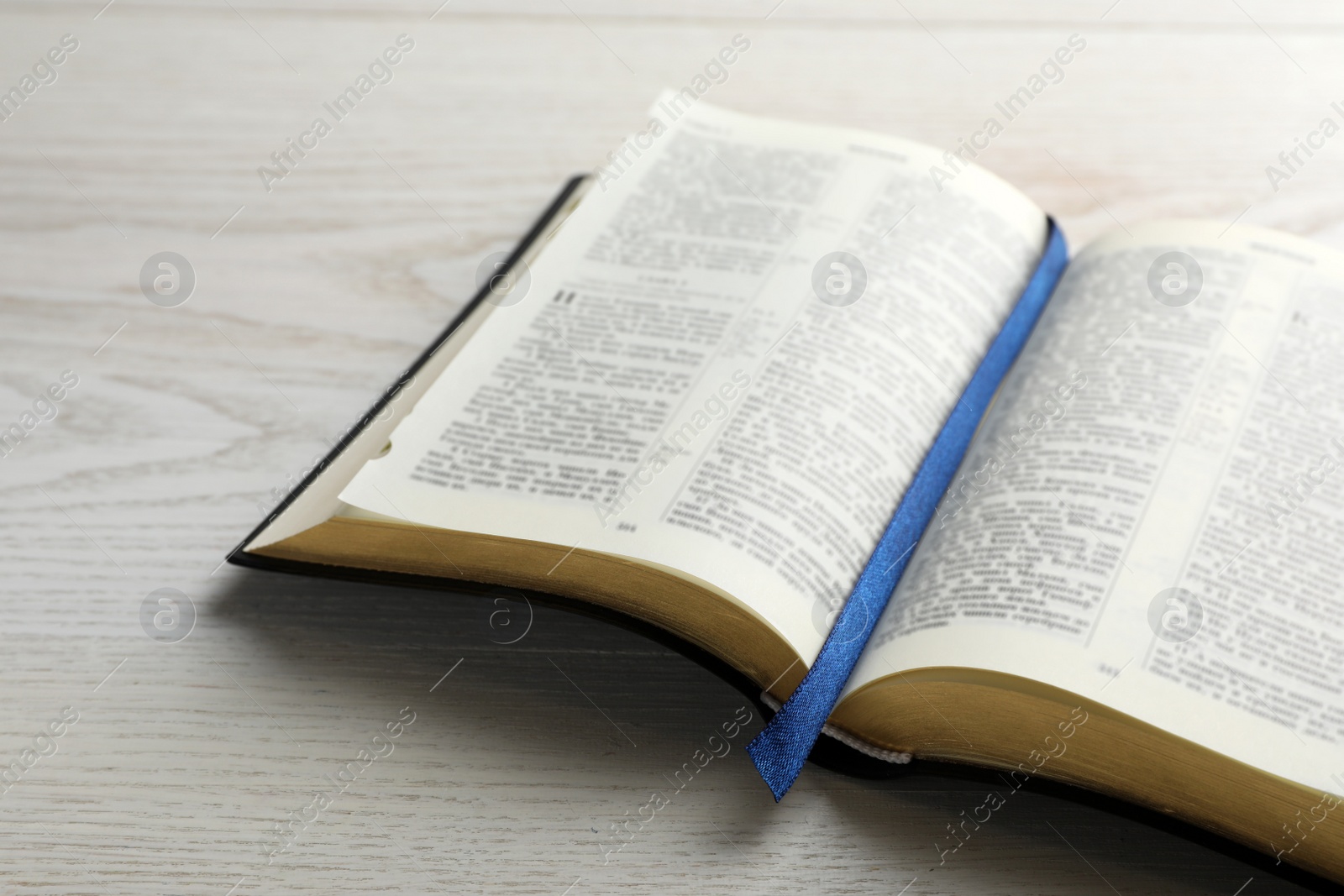 Photo of Open Bible on white wooden table. Christian religious book