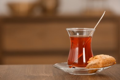 Photo of Tasty Turkish tea and baklava on wooden table indoors, space for text