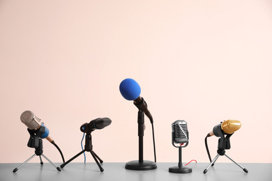 Different microphones on light grey table. Journalist's work