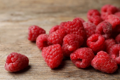 Heap of delicious ripe raspberries on wooden table, closeup