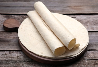 Photo of Delicious rolled Armenian lavash on wooden table
