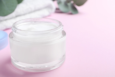 Photo of Open jar of cream on pink background, closeup. Space for text
