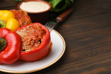 Photo of Delicious stuffed bell peppers served on wooden table, closeup. Space for text