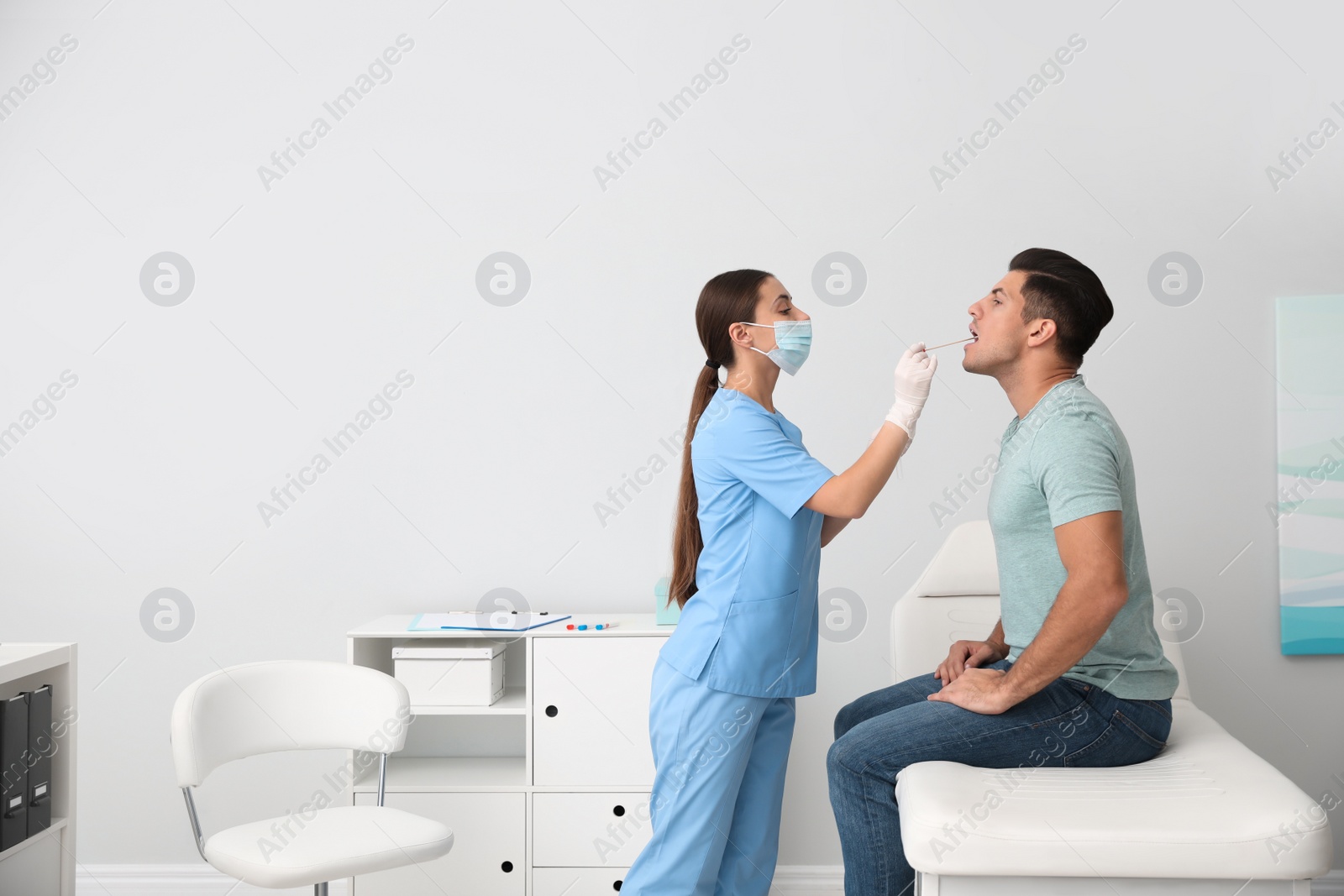 Photo of Doctor taking sample for DNA test from man in clinic