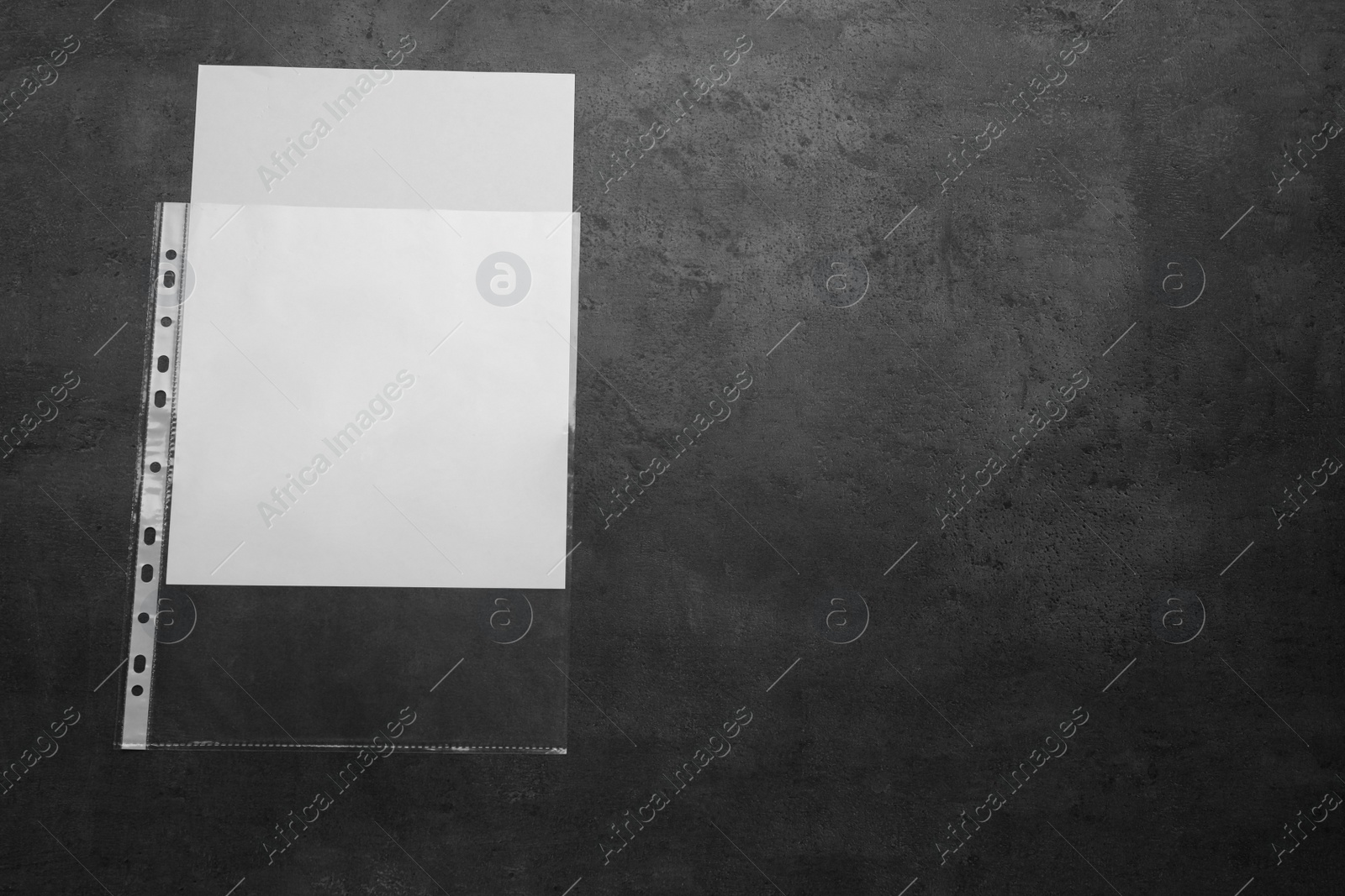 Photo of Punched pocket with paper sheet on grey background top view. Space for text