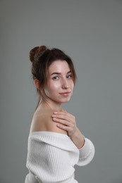 Portrait of beautiful young woman on grey background