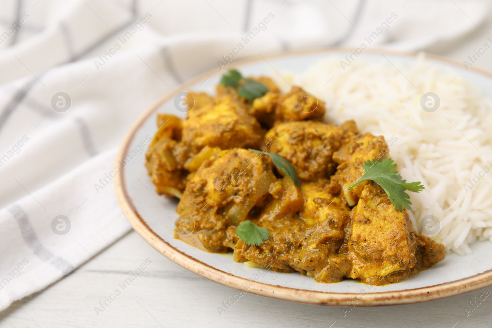 Photo of Delicious chicken curry with rice on table, closeup