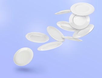 Image of Many white plates falling on pastel blue violet background