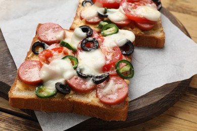 Tasty pizza toasts on wooden table, closeup