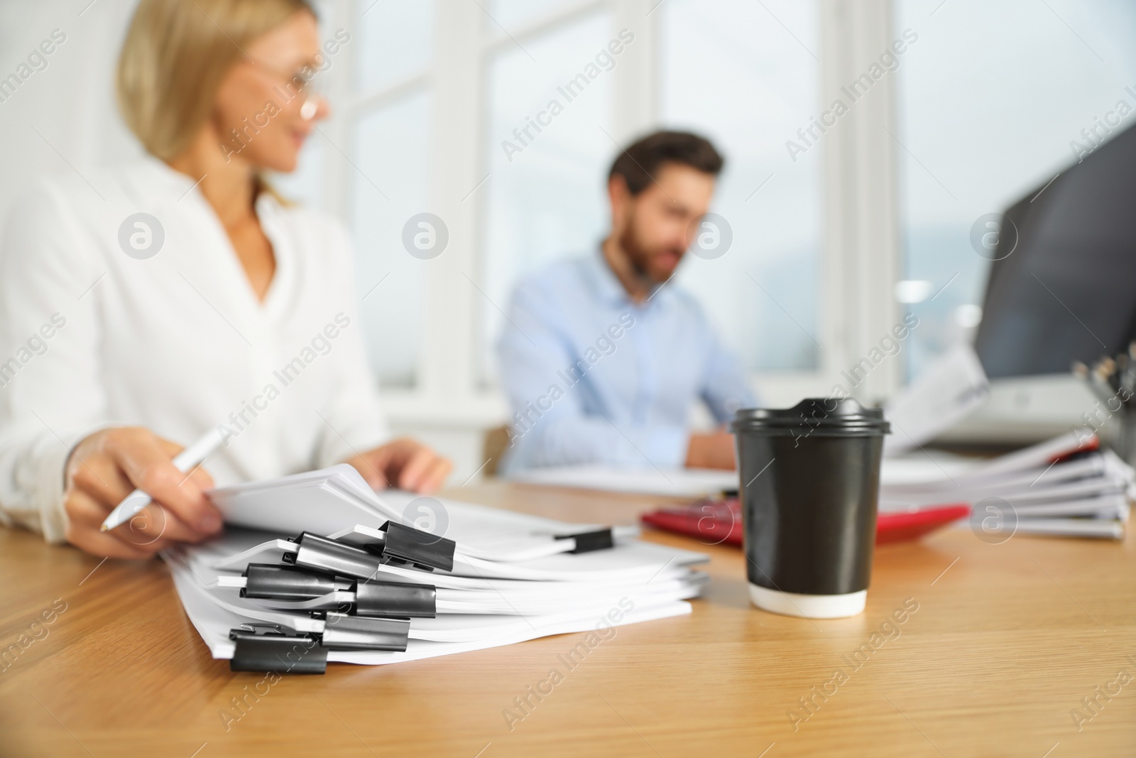 Photo of Businesspeople working at wooden table in office, focus on documents
