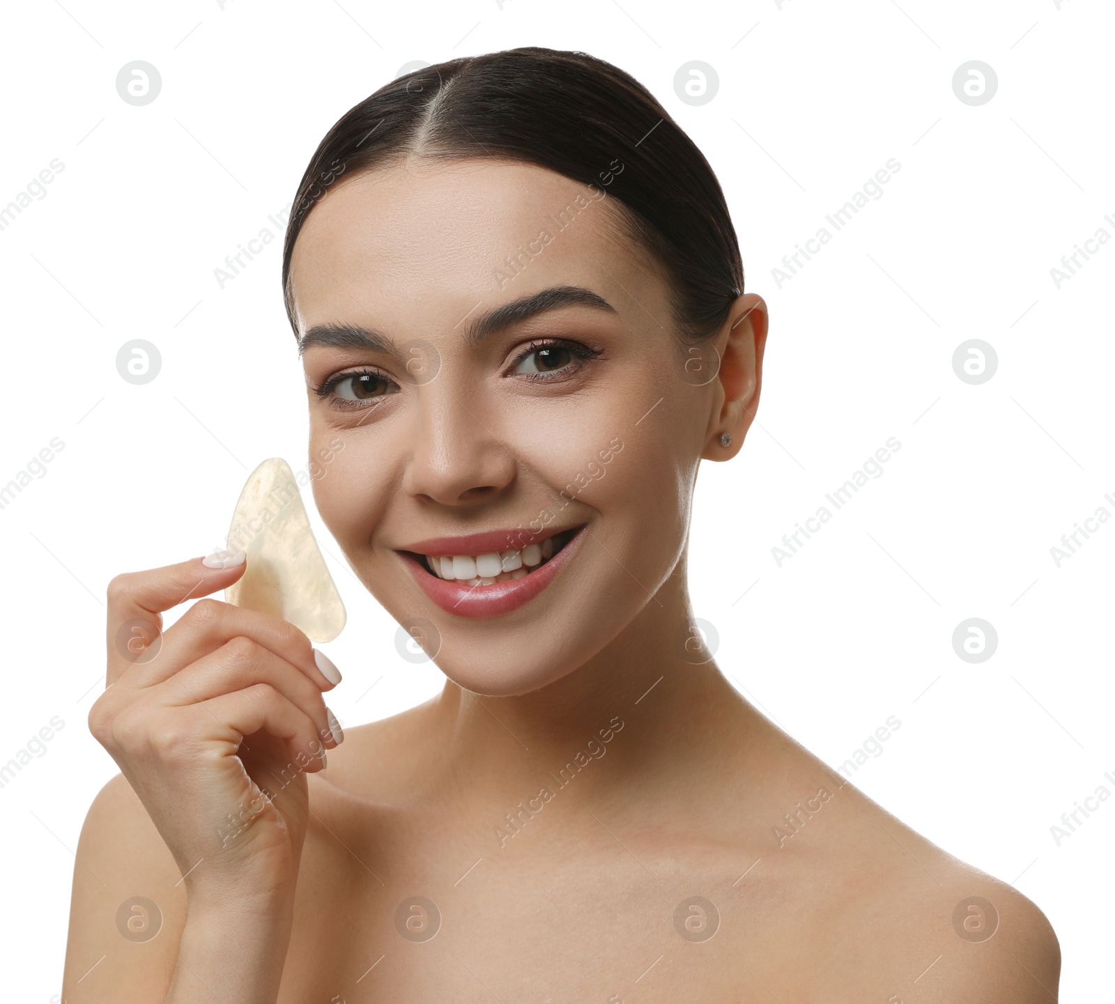 Photo of Beautiful young woman doing facial massage with gua sha tool on white background