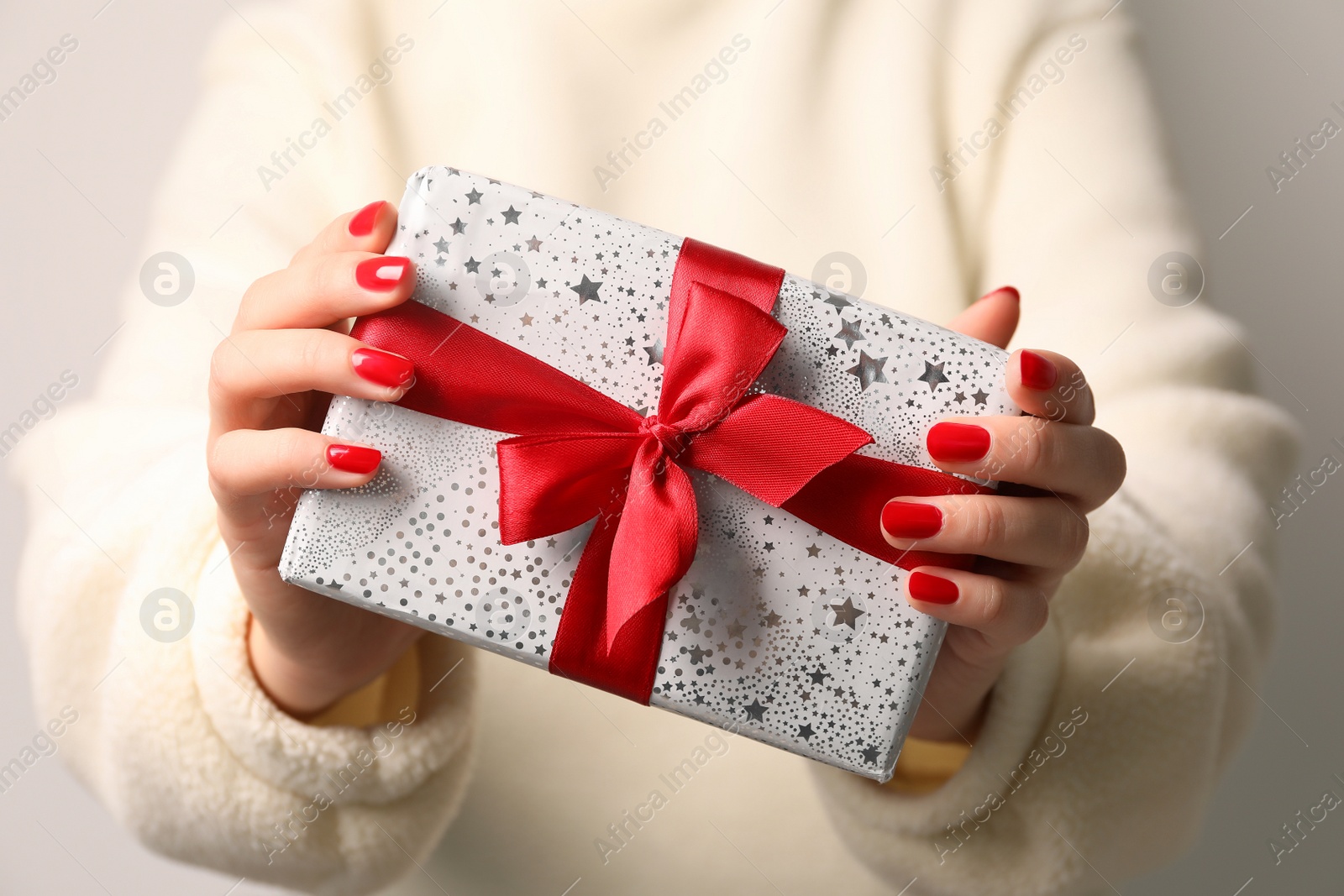 Photo of Christmas present. Woman holding gift box, closeup