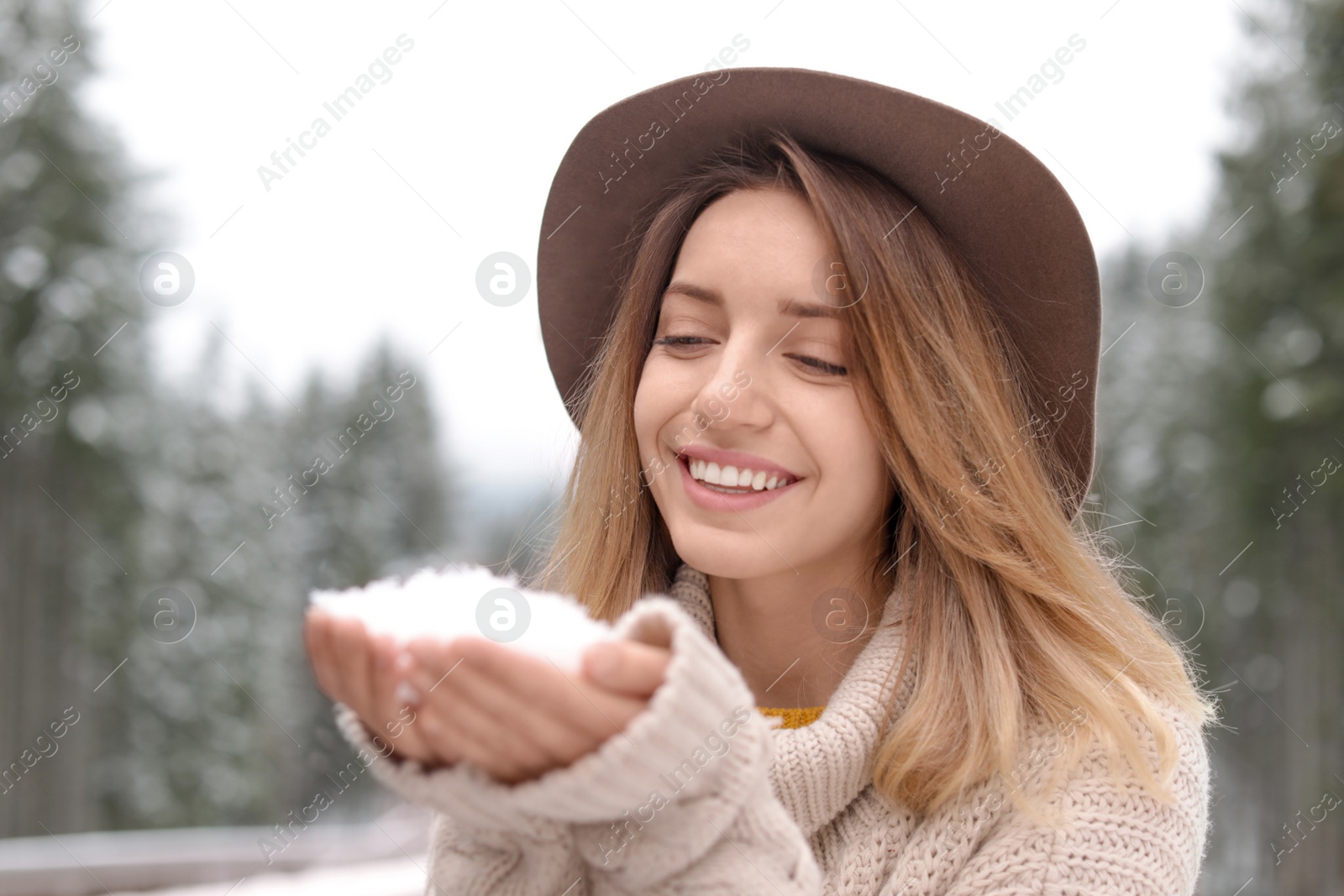 Photo of Young woman playing with snow outdoors. Winter vacation