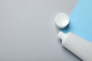 Photo of Blank tube of toothpaste and lid on color background, flat lay. Space for text