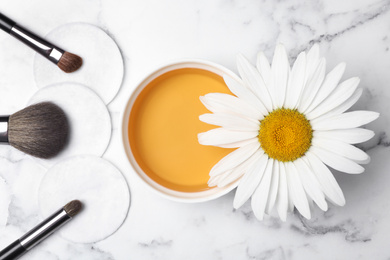 Photo of Flat lay composition with chamomile flower and cosmetic product on white marble table