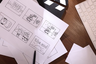 Photo of Storyboard with cartoon sketches at workplace, flat lay. Pre-production process