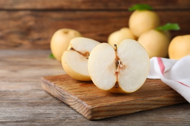Photo of Halves of ripe apple pear on wooden table