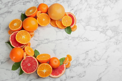 Photo of Letter C made with citrus fruits on marble table as vitamin representation, flat lay. Space for text