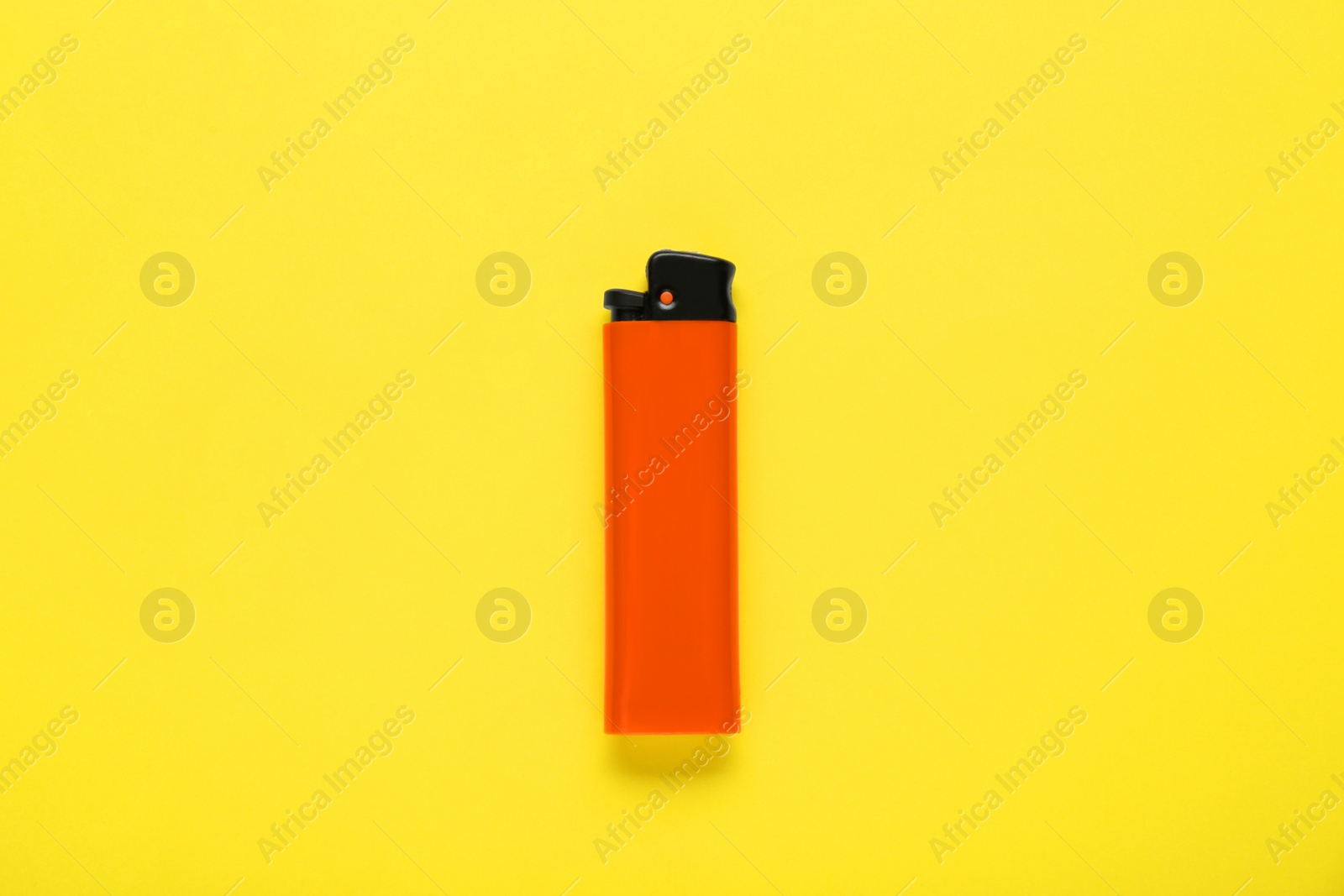 Photo of Stylish small pocket lighter on yellow background, top view