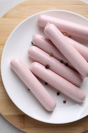 Photo of Vegan sausages with spices on wooden board, top view