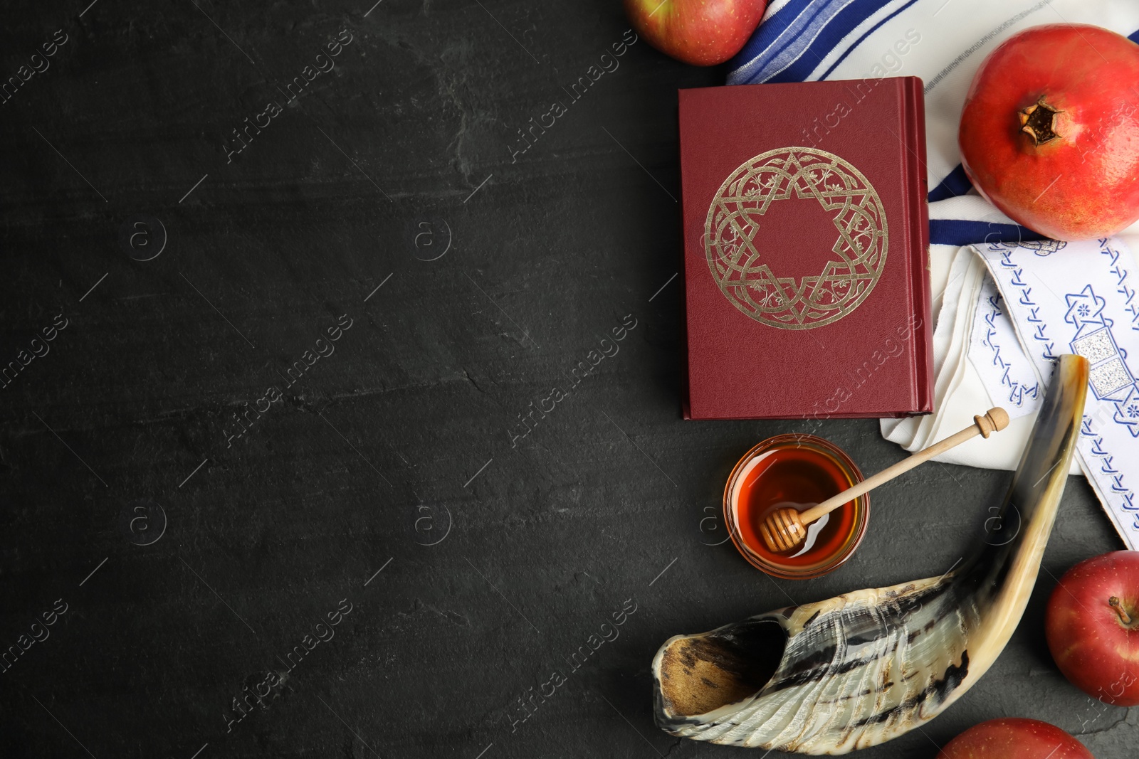 Photo of Flat lay composition with Rosh Hashanah holiday symbols on black table. Space for text