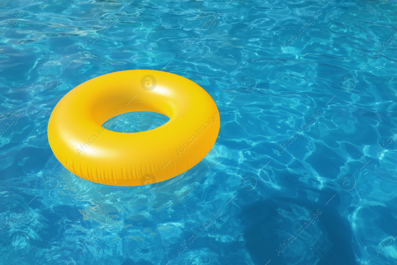 Photo of Inflatable ring floating in swimming pool on sunny day. Space for text