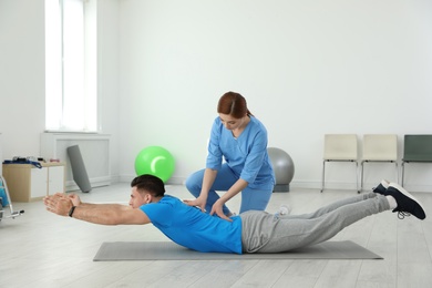 Photo of Professional physiotherapist working with male patient in rehabilitation center