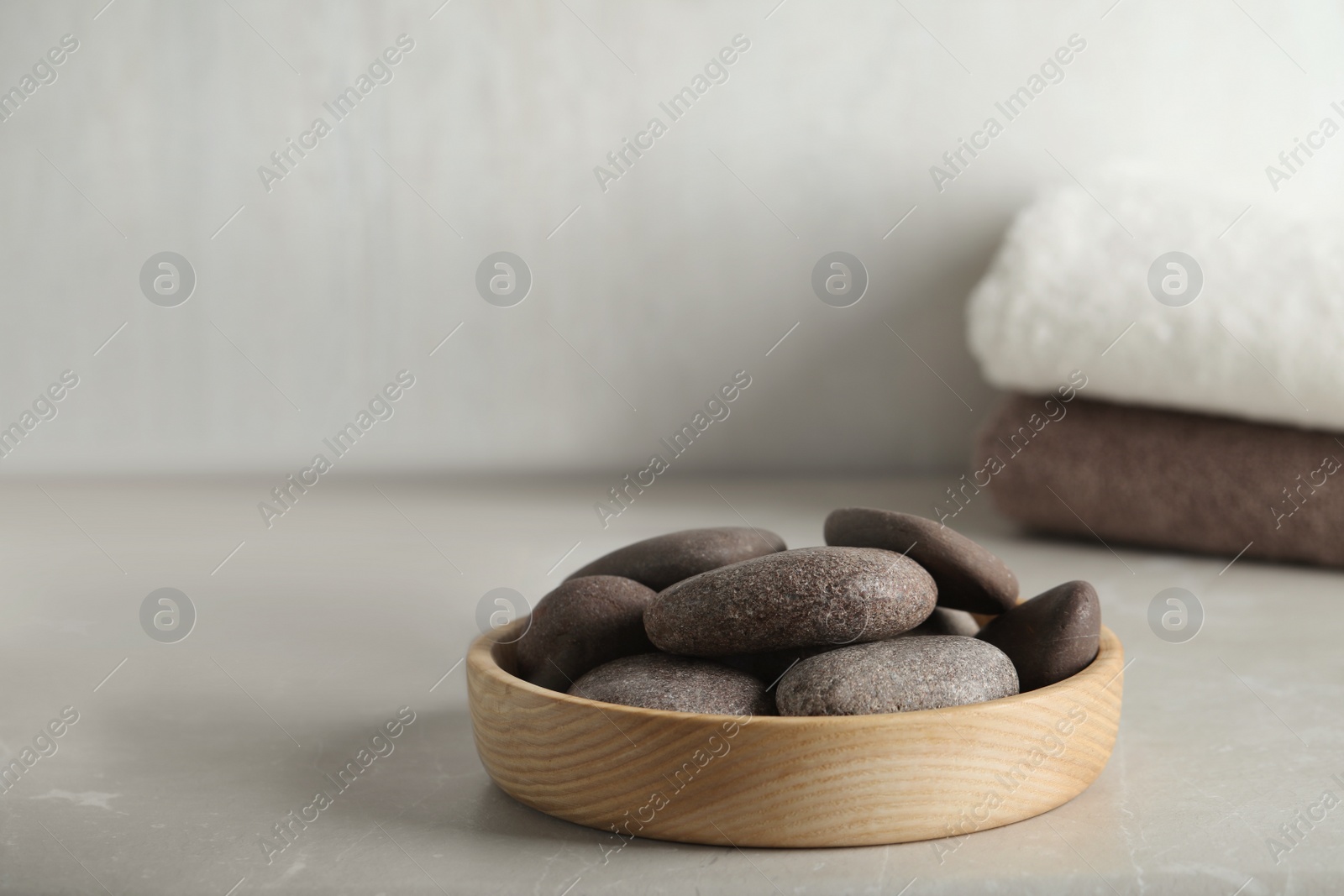 Photo of Spa stones in wooden tray on light table