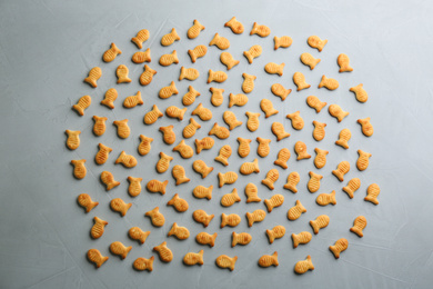 Photo of Delicious goldfish crackers on grey table, flat lay