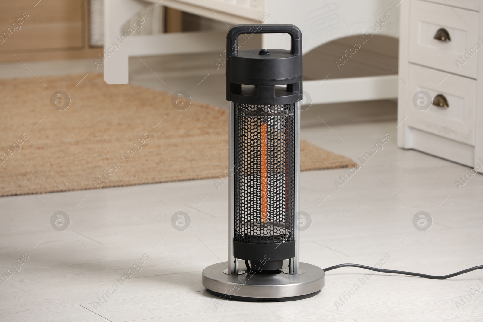 Photo of Modern infrared heater on floor in cozy room. Space for text