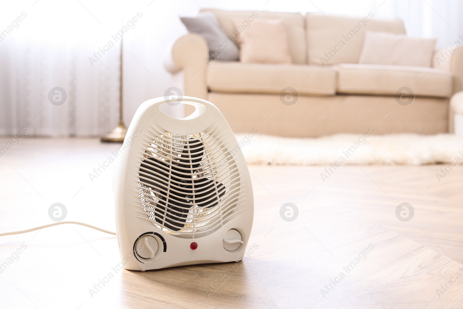 Photo of Modern electric fan heater on floor at home