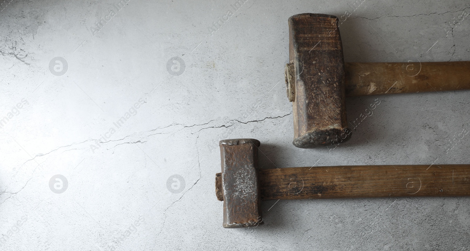 Photo of Two sledgehammers on grey background, top view. Space for text