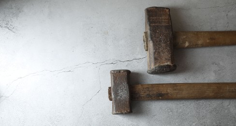 Photo of Two sledgehammers on grey background, top view. Space for text