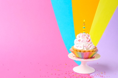 Delicious birthday cupcake with candle on color background. Space for text