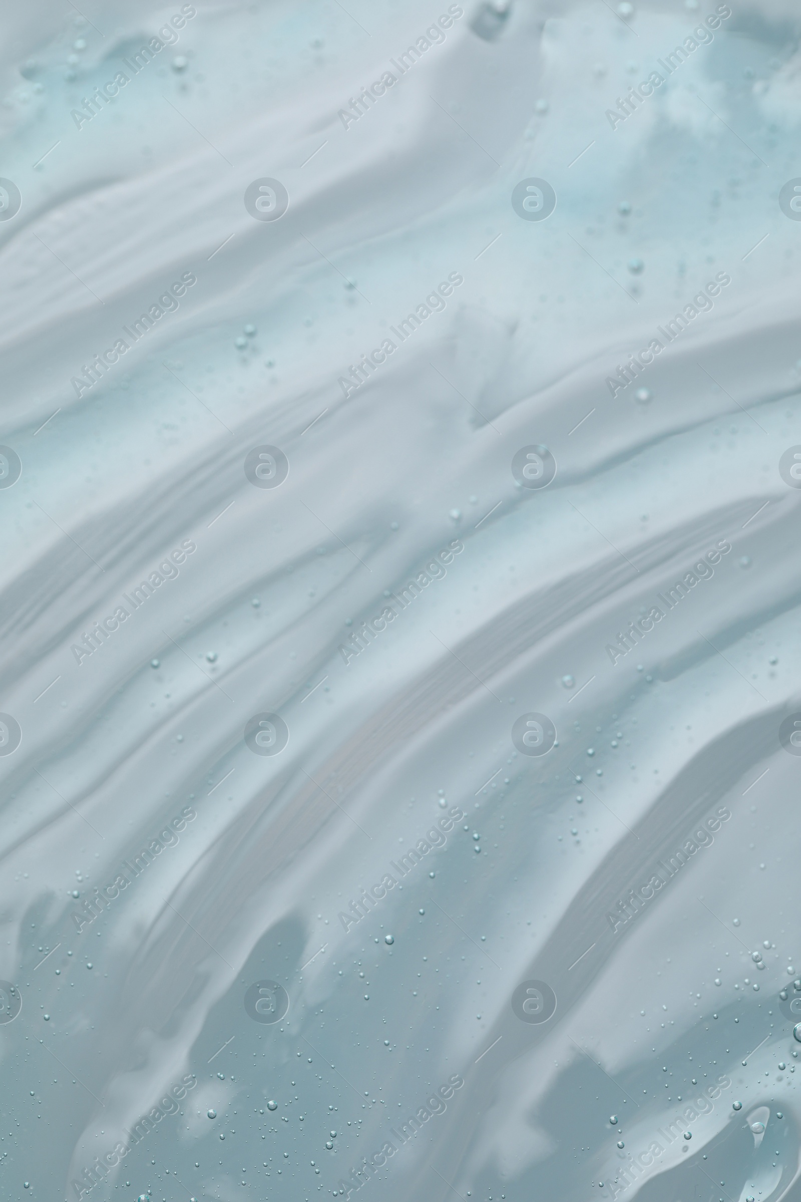 Photo of Transparent cleansing gel on dusty light blue background, top view. Cosmetic product