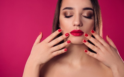 Beautiful woman with stylish nail polish on color background