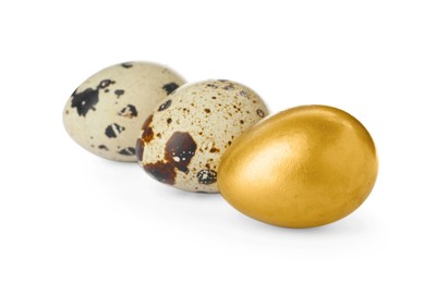 Golden egg and quail ones on white background