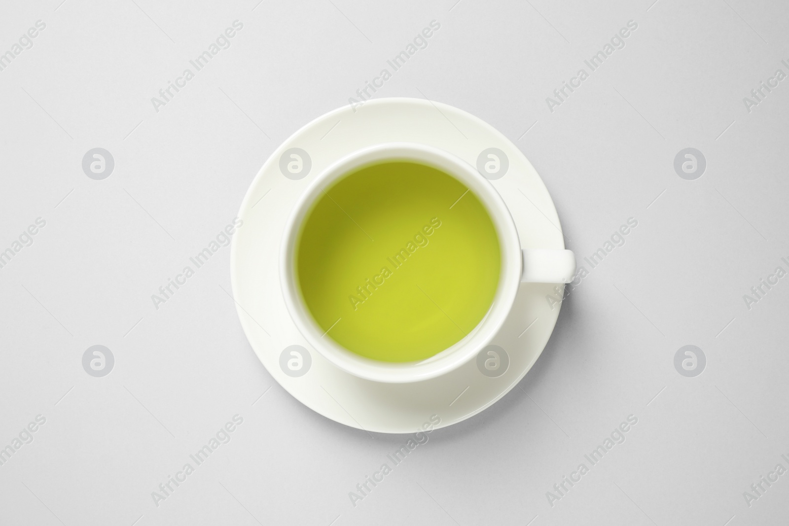 Photo of Cup of green tea on light background, top view